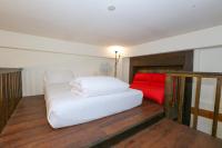 a bedroom with a white bed and a red couch at New Life Hot Spring Resort in Yuli
