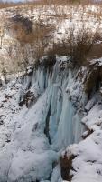 a frozen waterfall with snow on the side of it at Apartment King in Seliste Dreznicko