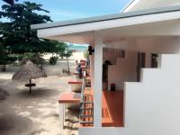 a building on the beach with tables and chairs at Nice Sea Resort in Srithanu
