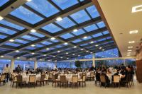 Dalaman Airport Lykia Thermal & Spa Hotel في دالامان: مجموعة كبيرة من الناس يجلسون على طاولات في غرفة كبيرة