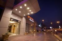 a building with a neon sign in a parking lot at لي لي جراند للشقق المخدومة - درجة اقتصادية in Al Hofuf