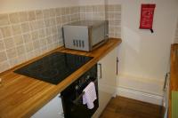 a microwave sitting on top of a counter in a kitchen at Garden Suite in Rhuddlan