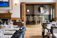 uma sala de jantar com mesas e cadeiras e um espelho em Hotel Du Vin & Bistro Brighton em Brighton & Hove