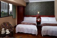 a hotel room with two beds and a chair at Gene Long Haiy Att Hotel in Chiayi City