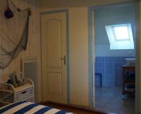 a bedroom with a door leading to a bathroom at La Grande Mare in Saint-Benoît-des-Ondes