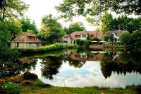 a group of houses sitting next to a lake at Au Moulin de La Gorce in La Roche-lʼAbeille