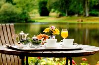 a table with a tray of food and a glass of orange juice at Au Moulin de La Gorce in La Roche-lʼAbeille