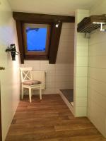 a walk in shower with a chair and a window at Pension Karina Schwerin in Schwerin