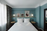 1 dormitorio con 1 cama grande y paredes azules en XO Hotel Paris, en París