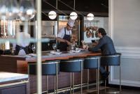 two chefs preparing food in a restaurant kitchen at Four Seasons Hotel Amman in Amman