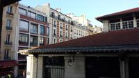 a building with a brown roof in a city at Aligre in Paris