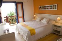 a bedroom with a white bed and a balcony at Pousada DiMari in Boicucanga