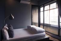 a bedroom with a bed with pillows and a window at Silom Space Hostel in Bangkok