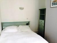 a bedroom with a white bed and a green dresser at Hôtel De Normandie in Amiens