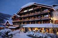 a large building with snow in front of it at Hôtel Alpina &amp; SPA in Les Gets