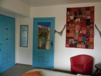 a room with a blue door and a red chair at Le Logis d&#39;ANTIGNY in Val-du-Mignon
