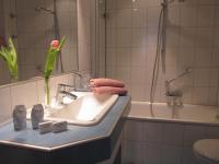 a bathroom with a sink and a bath tub with a flower at Hotel Anlage Heidelberg in Heidelberg