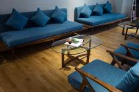 a living room with blue couches and a glass table at Silverland Yen Hotel in Ho Chi Minh City