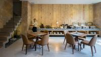 a woman standing in a kitchen with tables and chairs at Silverland Yen Hotel in Ho Chi Minh City