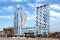 東営にあるWanda Realm Hotel Dongyingの都内に二つの塔がある高い建物