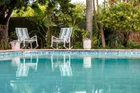 2 sillas sentadas junto a una piscina en Admirals Lodge Guest House and Brightways self catering apartments, en Port Elizabeth