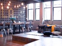 a dining room with a table and chairs with pillows at Silom Space Hostel in Bangkok
