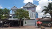 una casa blanca con un árbol delante en KampongBay Makeng II Guesthouse, en Kampot