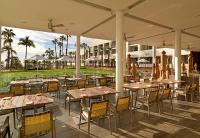 um restaurante ao ar livre com mesas, cadeiras e palmeiras em Paradisus Los Cabos - Adults Only - All Inclusive em Cabo San Lucas