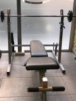a bench in a gym with a barbell at Hôtel Jacques De Molay in Paris