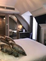 a bed with two large cushions on top of it at Hôtel Jacques De Molay in Paris