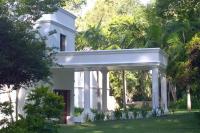 una casa blanca con árboles delante en Edenbrook Country Manor, en Plettenberg Bay