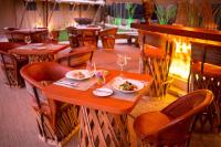 un restaurante con una mesa con un plato de comida. en Serenity Authentic Glamping Tulum, en Xpu-Ha