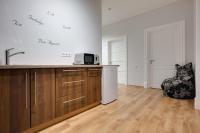 a kitchen with a sink and a microwave and a chair at Orange Cat Rooms in Riga