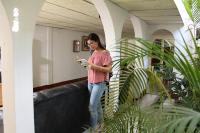 Una mujer parada en un pasillo mirando su celular en El Callejon Guest House, en León