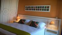 a bedroom with a white bed with two lamps at Pousada DiMari in Boicucanga