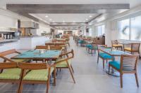 um restaurante com mesas e cadeiras de madeira e uma cozinha em Wyndham Garden Playa del Carmen em Playa del Carmen