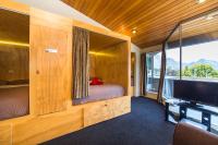 a room with a bed and a tv in a room at Tahuna Pod Hostel in Queenstown
