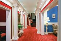 a hallway with white columns and a red carpet at Hôtel d&#39;Etigny in Luchon