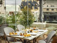 a table with food and wine glasses on a balcony at The Principal Madrid, Small Luxury Hotels in Madrid