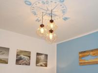 a clock on a ceiling with a chandelier at Fischerhaus Bremerhaven in Bremerhaven