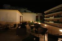 a rooftop patio with tables and chairs at night at Hotel Nice in Sorrento