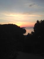 a sunset over a body of water with trees at Apartment Žarko in Brna
