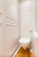 a white bathroom with a toilet and a shower at 1 Square du Docteur Blanche - Paris 16 in Paris