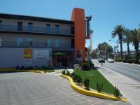 ein Gebäude an der Seite einer Straße mit Palmen in der Unterkunft Thunderbird Boutique Hotel in Las Vegas