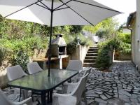 a table and chairs with an umbrella on a patio at Les Lauriers in Limoux