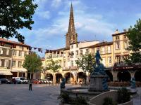 a town square with a fountain in front of a church at Les Lauriers in Limoux