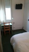 a bedroom with a bed and a desk and a window at Hôtel De Normandie in Amiens