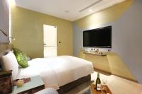 a bedroom with a large bed and a flat screen tv at Beauty Hotels Taipei - Hotel B7 in Taipei