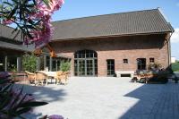 a brick building with a patio with a table and chairs at Hotel Oude Eycke in Maaseik
