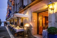 a restaurant with tables and a umbrella on a street at Baglioni Hotel Luna - The Leading Hotels of the World in Venice